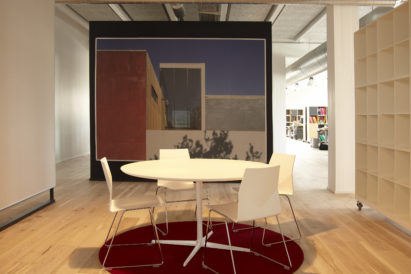 small circular red rug under white table in office