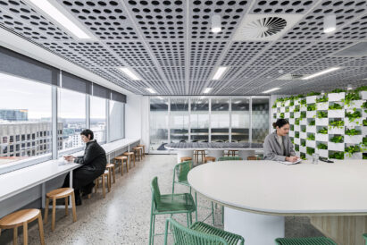 light grey sound absorbing ceiling tiles with circle cutout pattern above lounge area