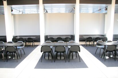 lounge area with dark grey wool felt rugs under table and chairs