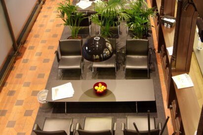 large dark green wool felt rug under chairs in lounge area