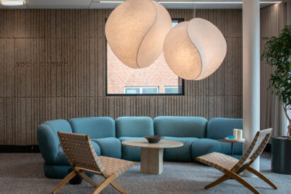 lounge area with blue circular couch and large lights suspended from ceiling